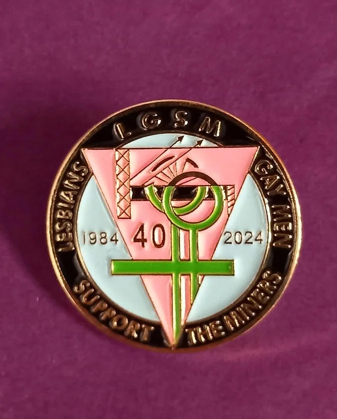 A circular enamel pin badges with a downward pin triangle in the centre. Along the rim is text that reads "LGSM Lesbians and Gays Support the Miners".
