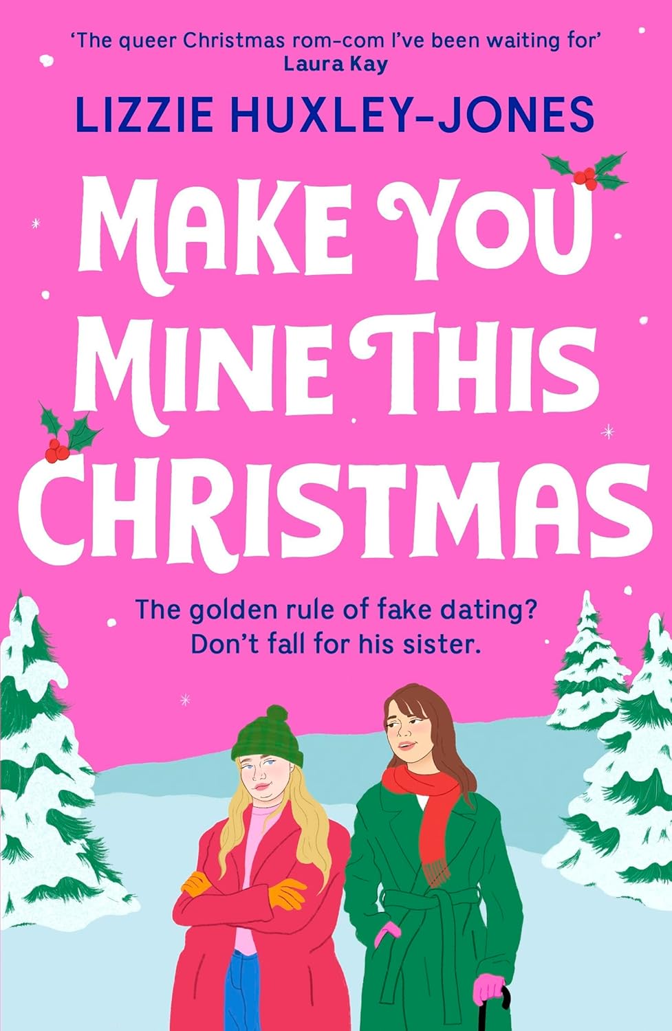 The cover of Make you mine at Christmas shows a bright pink sky at the top and a snow scene with three pine trees and snow at the bottom. The two figures on the front of the book are cartoon drawn women, one is wearing a green coat, pink gloves and a red scarf. She has long brown hair and she is holding a cane. The other woman is wearing a pink coat, orange gloves and a green hat. She has long blonde hair. The title of the book is written in large white letters with holly around the letters. 