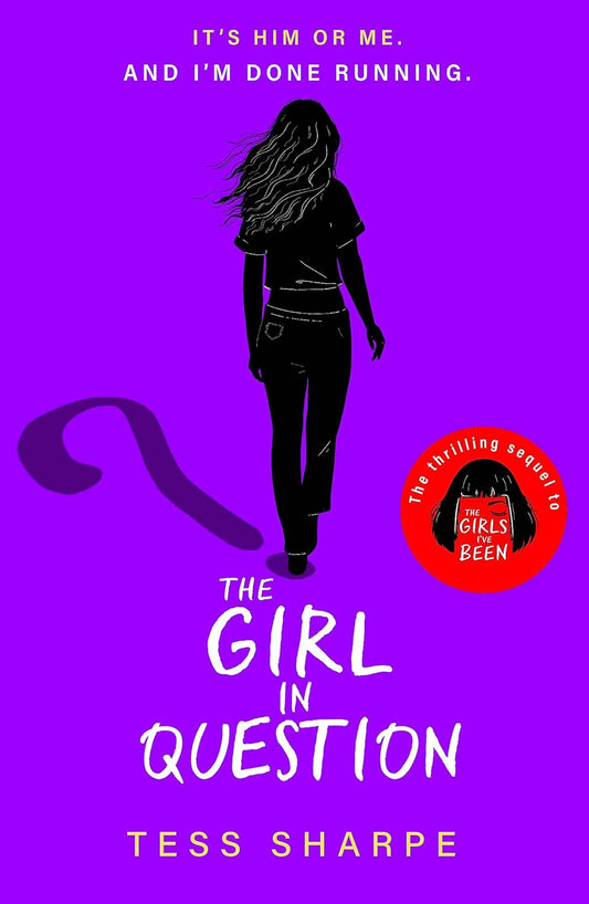 The paperback book for The Girl in Question has a bold purple background with a black silhouette of a young woman walking away from the viewer. Her shadow is a question mark. Above this is text that reads "It's him or me. And I'm done running."